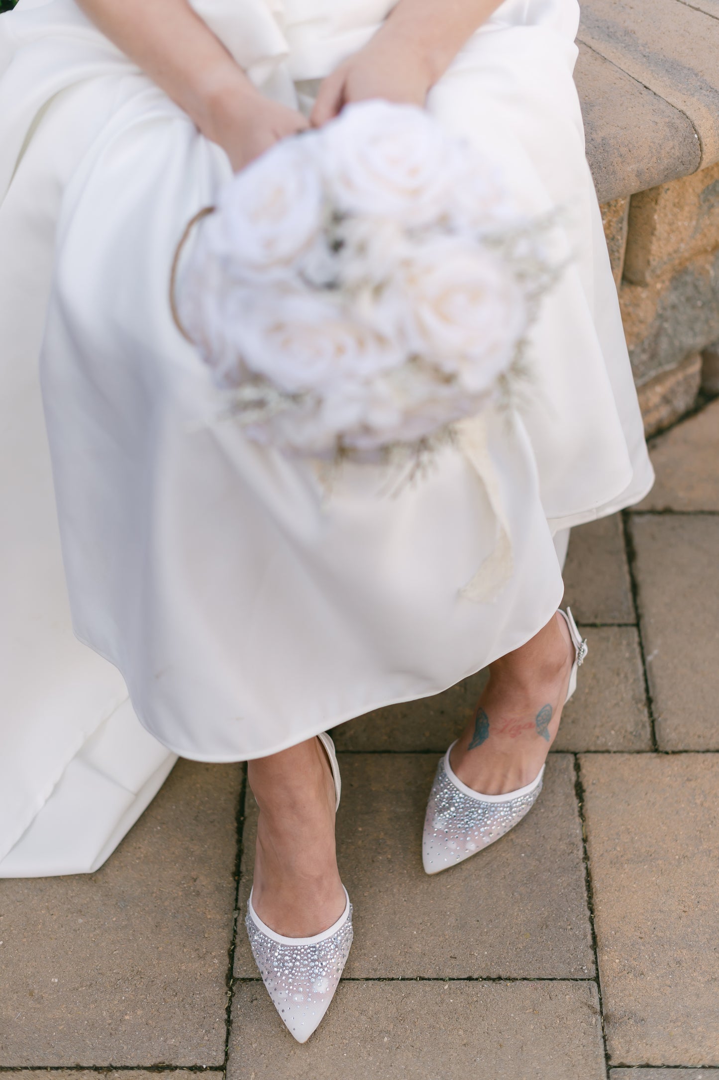 White d’orsay pump with adjustable slingback and a 3.5" heel worn by a woman in a white dress