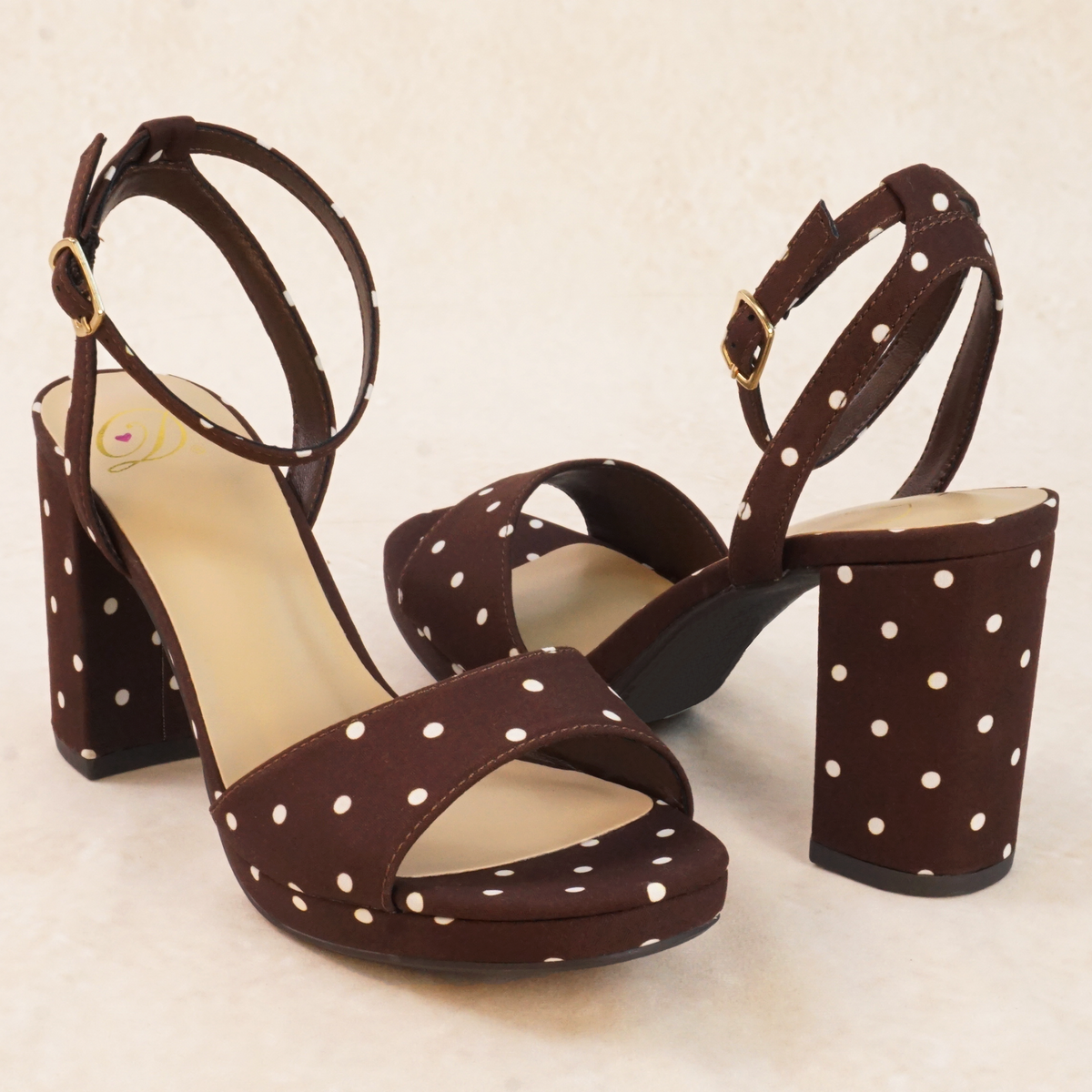 Brown polka dot print heeled sandals with adjustable ankle strap and buckle