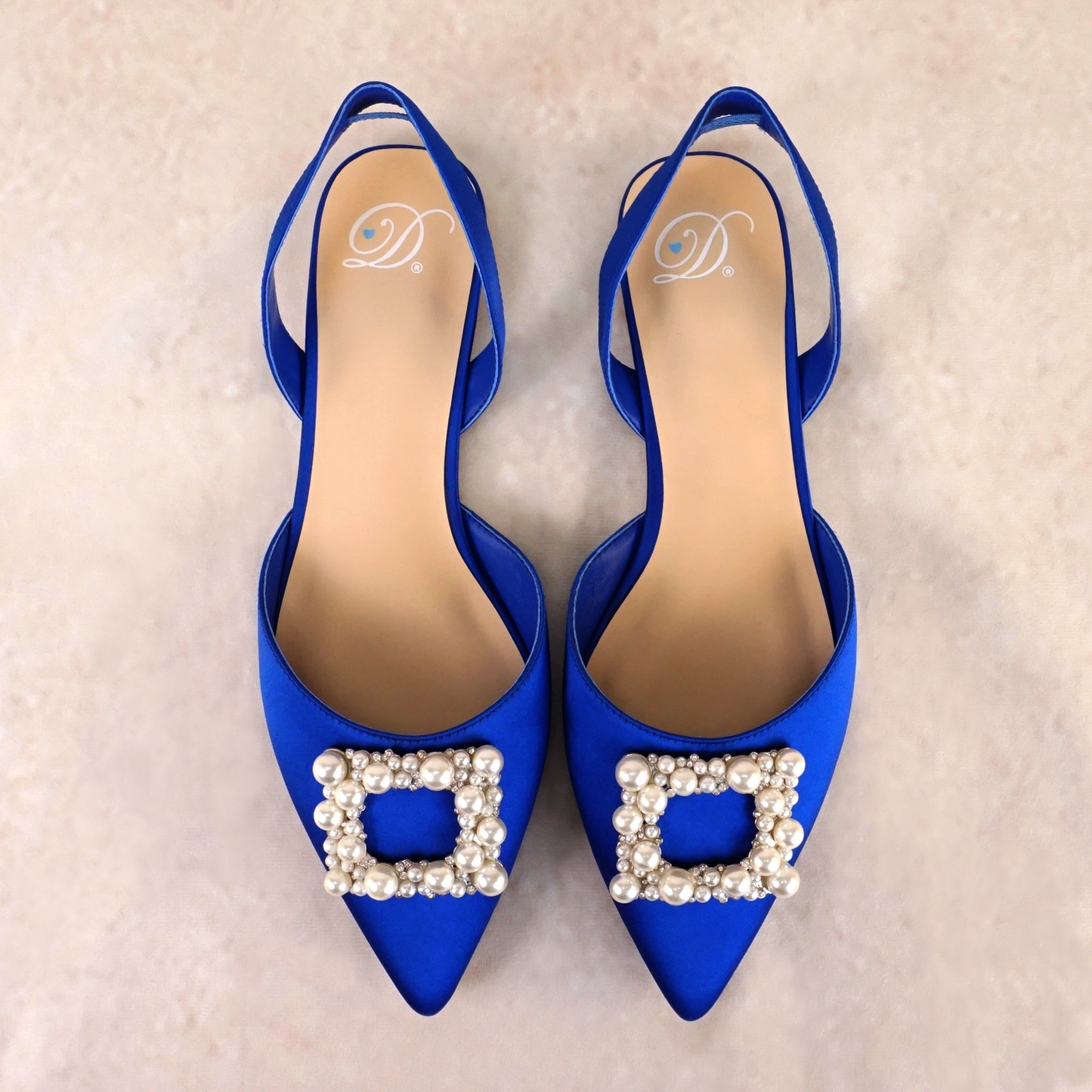 Slingback flat with a pearl buckle accent in a cobalt satin PU