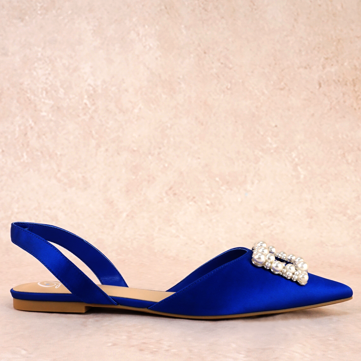 Slingback flat with a pearl buckle accent in a cobalt satin PU