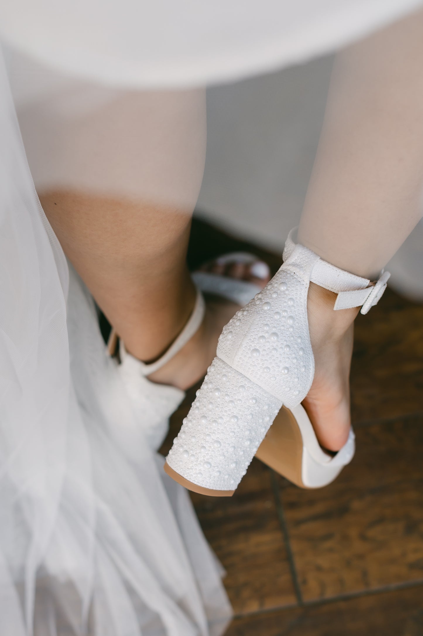 Allover pearl 3.6" block heel single band sandal in white with 1" platform worn by a woman in a white dress