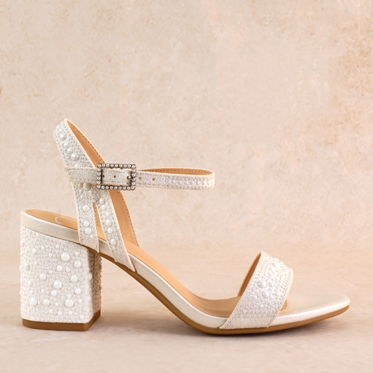A 2.75" low block heel with allover pearls and ankle strap in white
