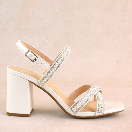 A white block heel with pearl and rhinestone adjustable ankle straps and cross strap across the toes