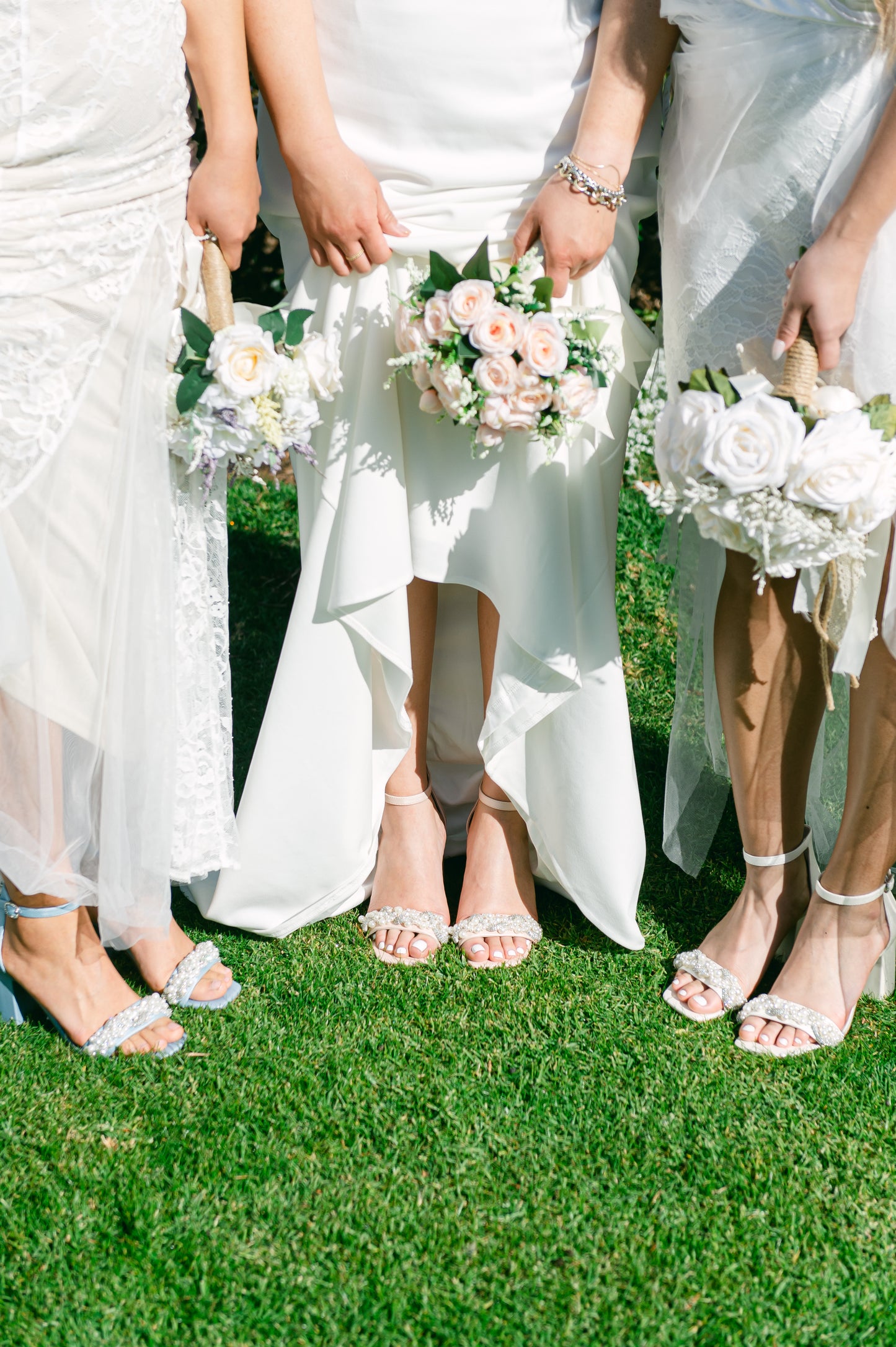 Pearls and rhinestones intertwined on blue, pink and white single-band 3.25" ankle strap block heels worn by three women in white dresses