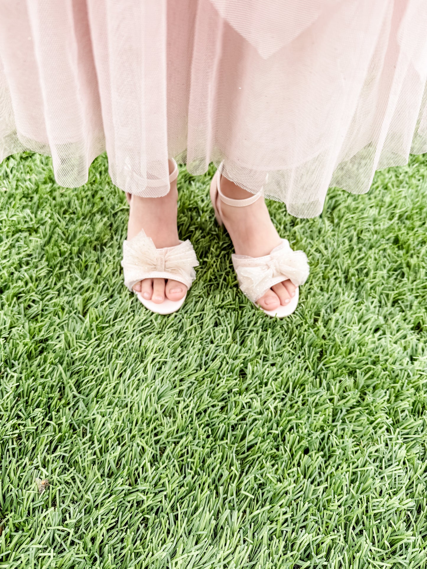 1.75" block heel pink sandal with tulle glitter bow detail being worn