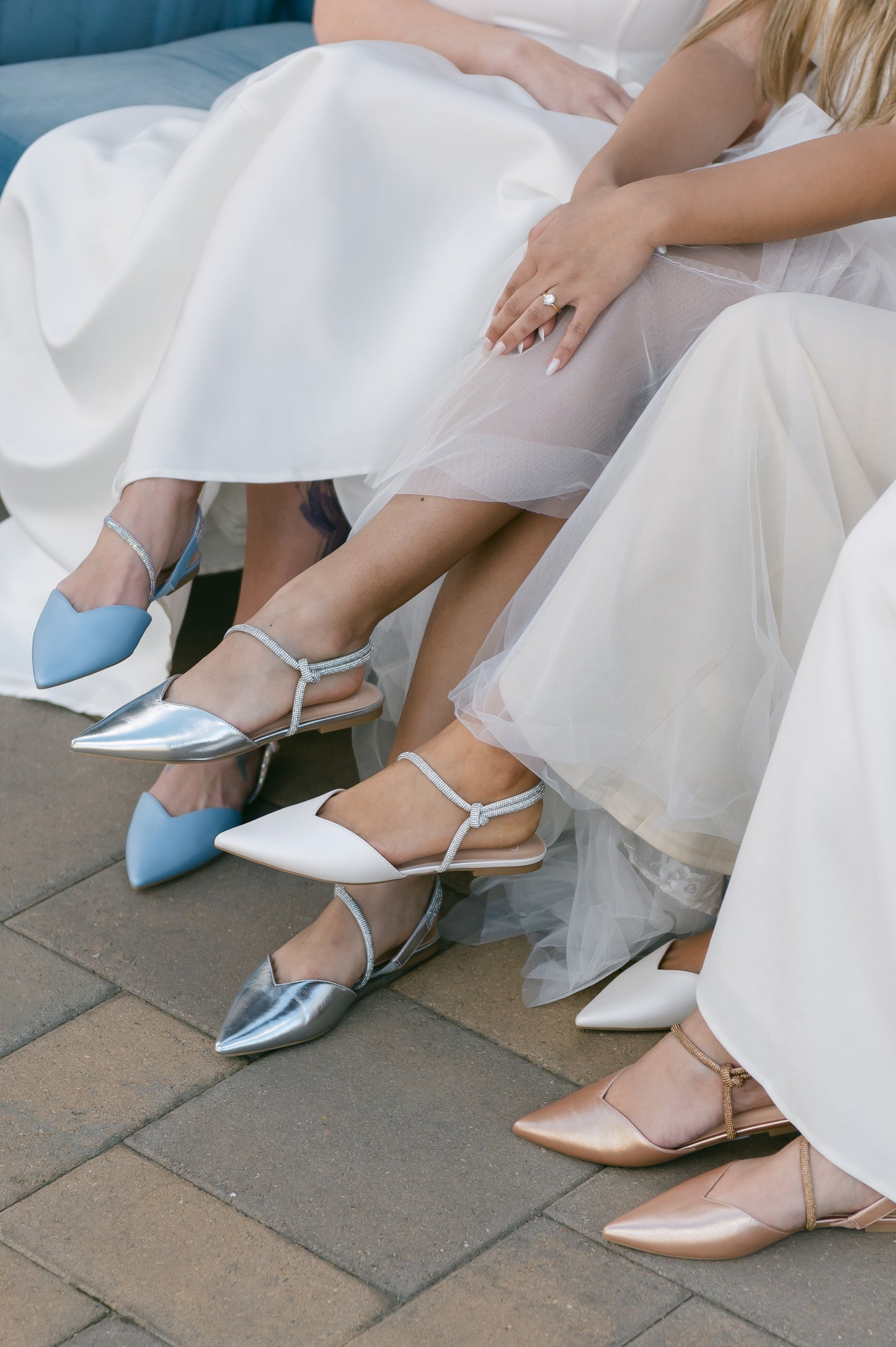 Pointed-toe slingback flats with rhinestone strap in white, blue and silver being worn by women in white dresses