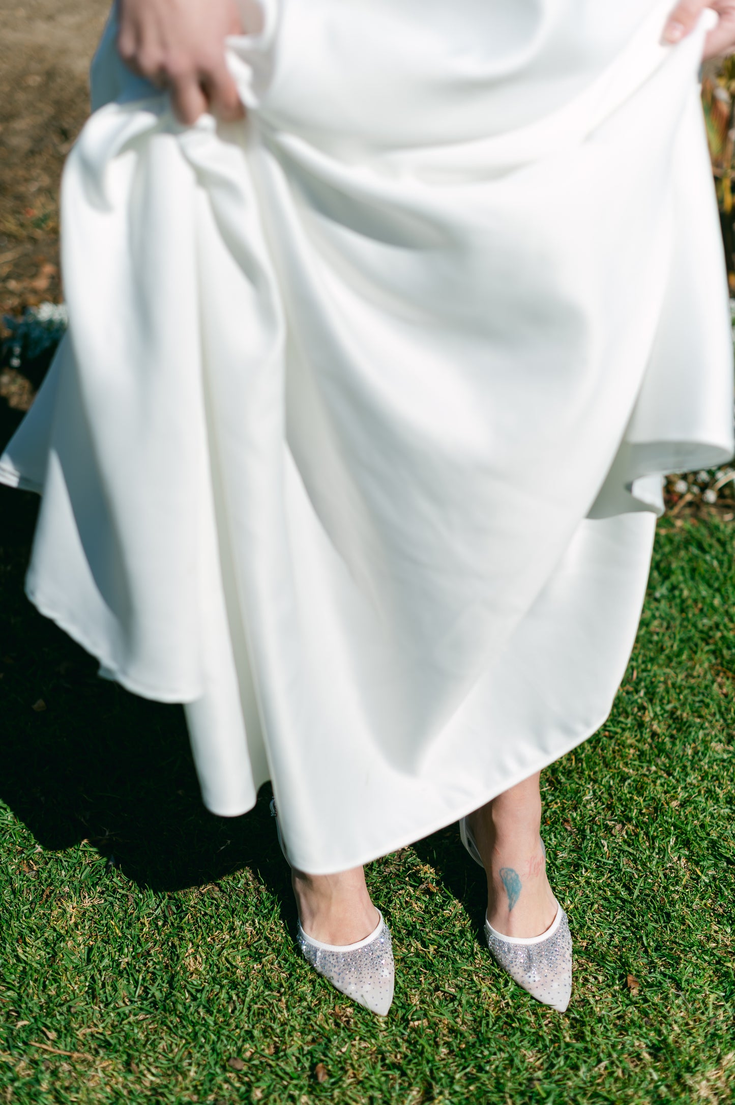 White d’orsay pump with adjustable slingback and a 3.5" heel worn by a woman in a white dress