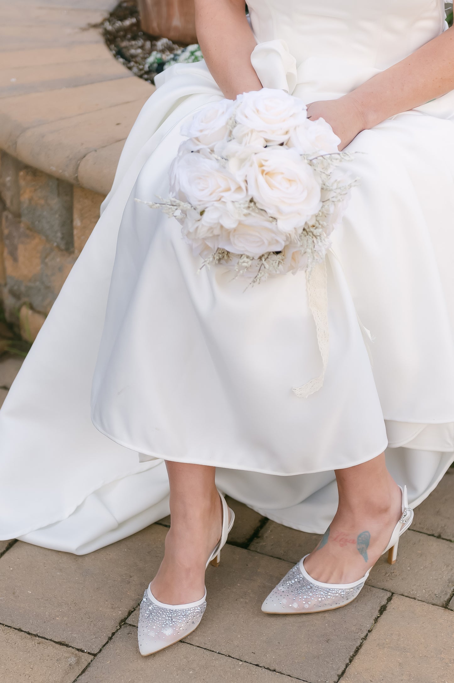 White d’orsay pump with adjustable slingback and a 3.5" heel worn by a woman in a white dress