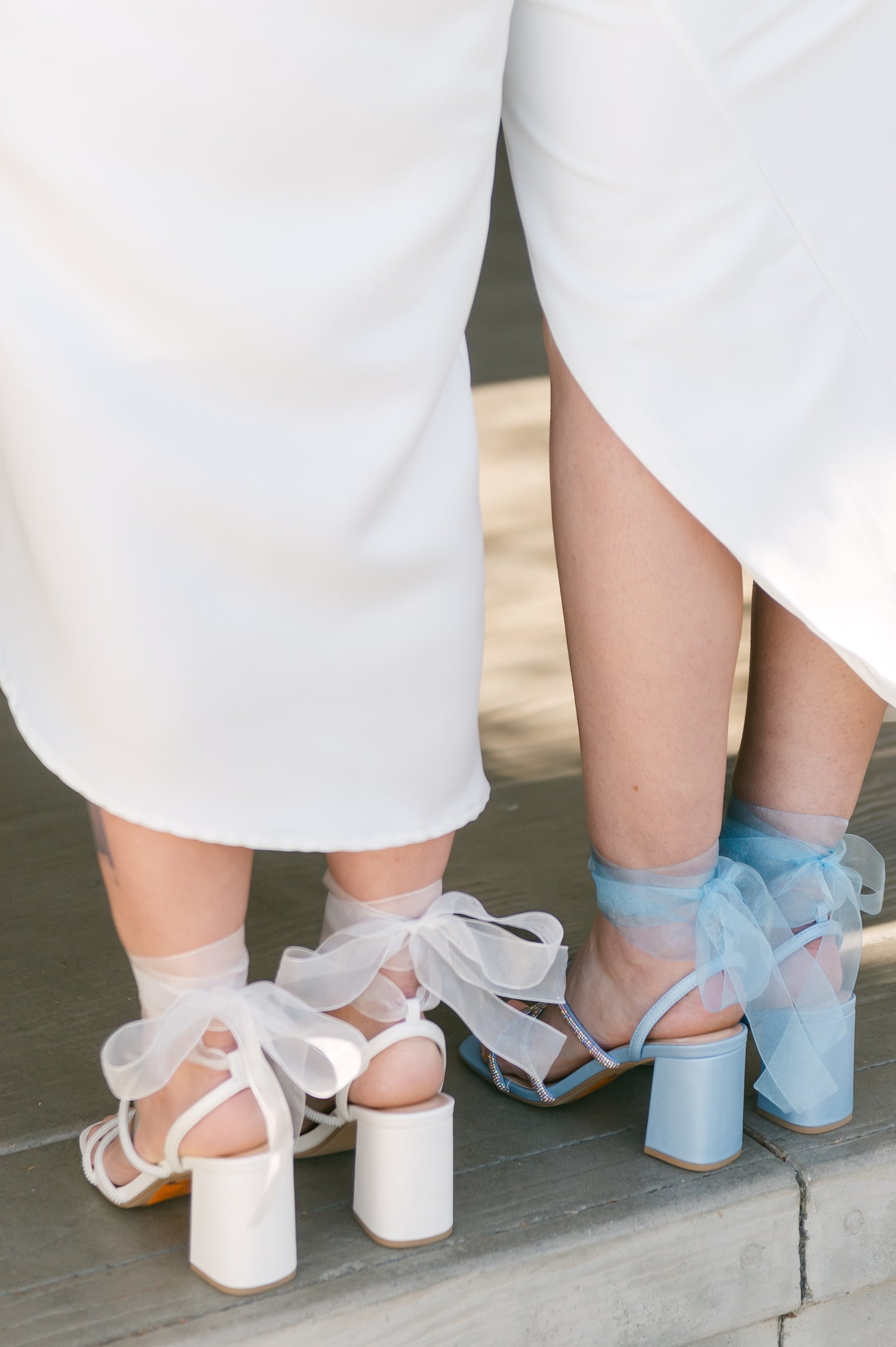 3.25" block heels in blue and white with rhinestone straps and a sheer ribbon ankle tie worn by two women in white dresses