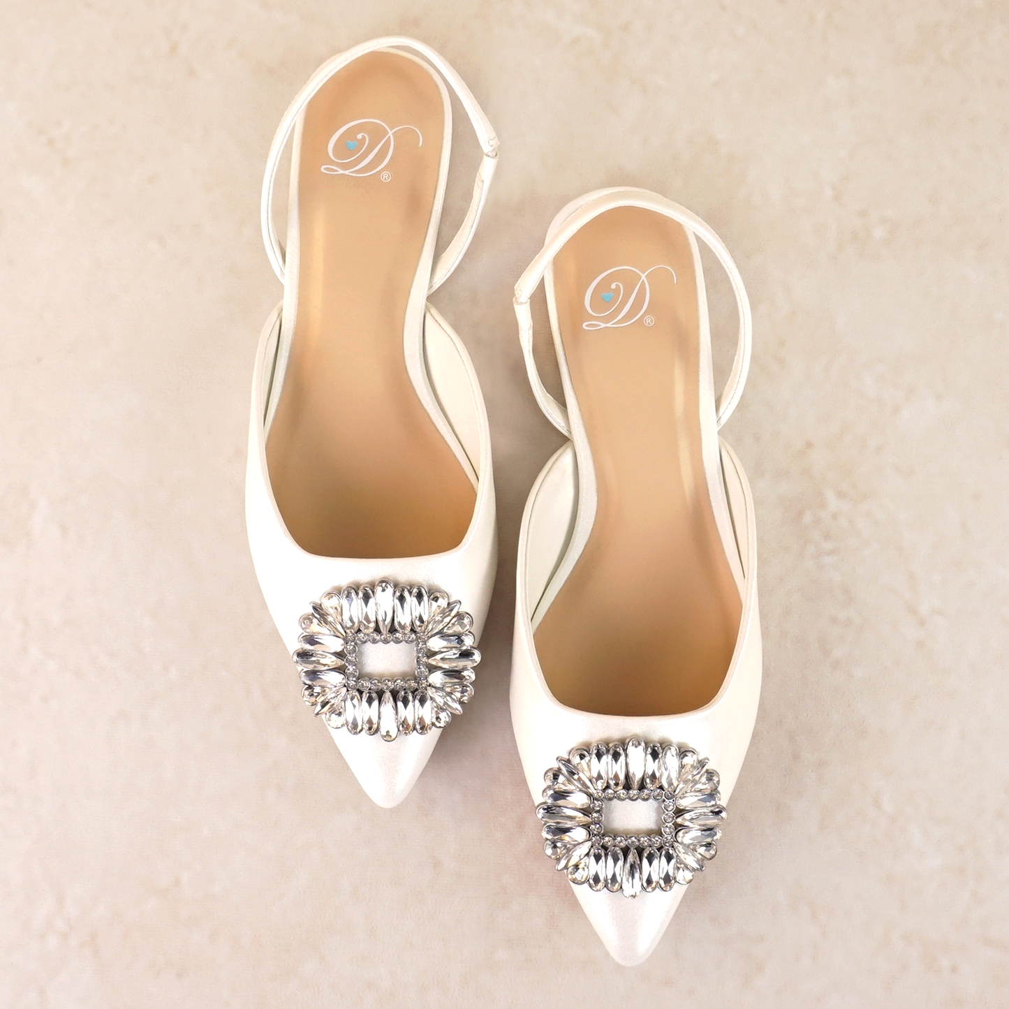 White pointed-toe slingback flat with rhinestone accent
