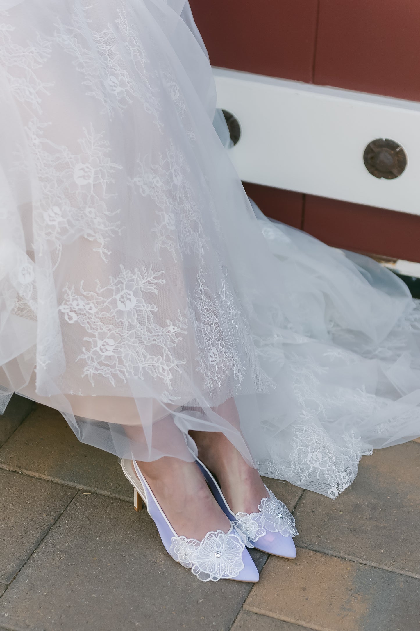 White mesh elasticized slingback pointed-toe 3.5" pump with rhinestone flower detail worn by a woman in a white dress