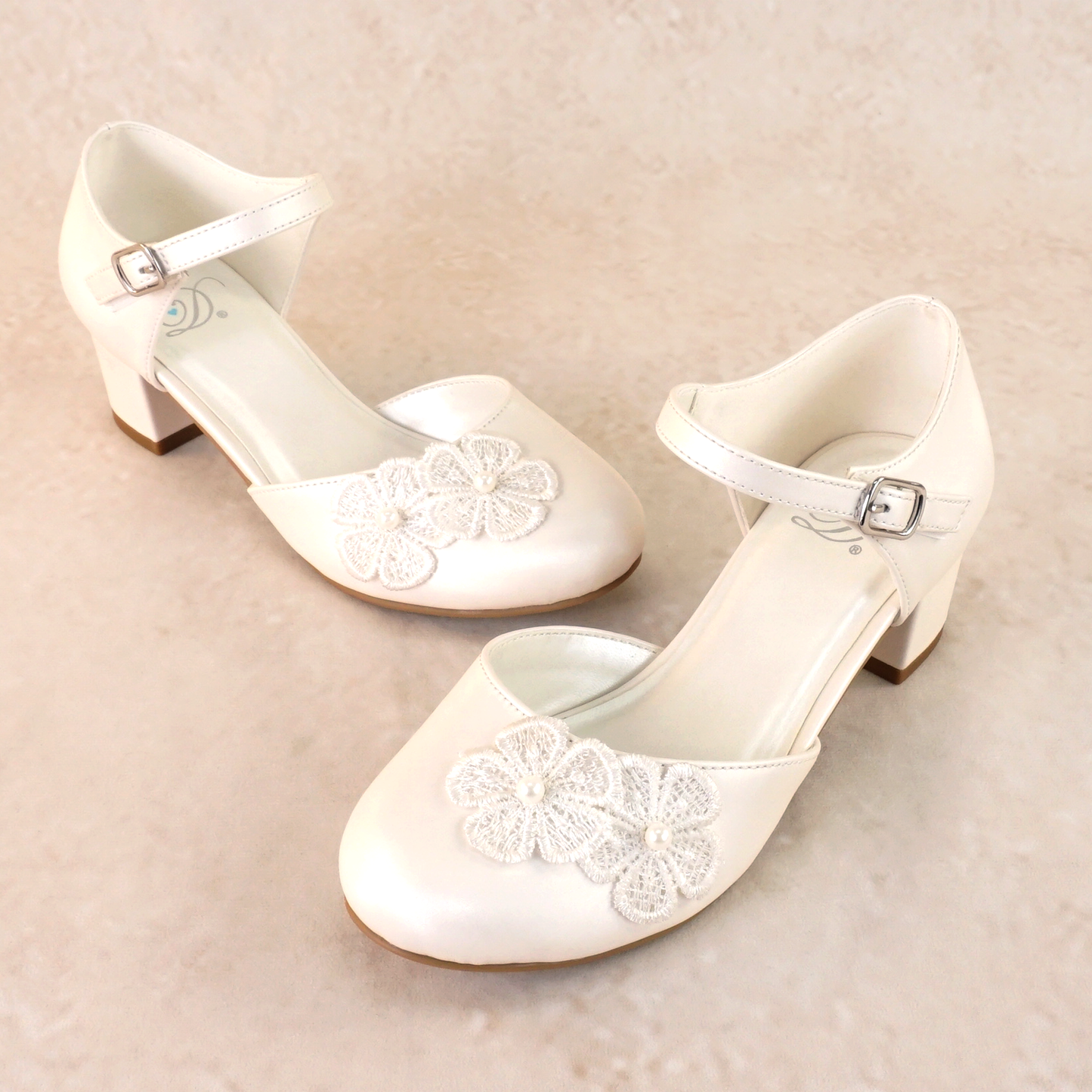 Closed-toe d’orsay white Mary Jane with floral applique detail and a 1.75" block heel