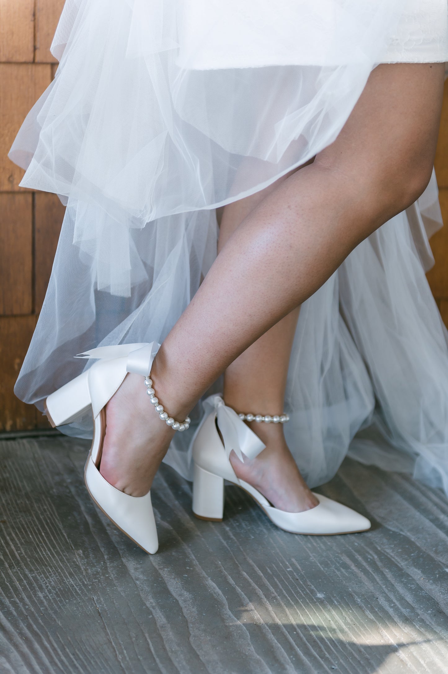 White d'orsay heel with adjustable pearl ribbon ankle tie and a 3.25" block heel worn by a woman in a white dress