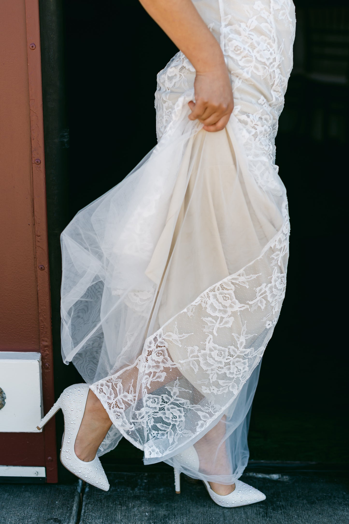 White cut-out stiletto with pearls all over and a 4.25" heel worn by a woman in a white dress