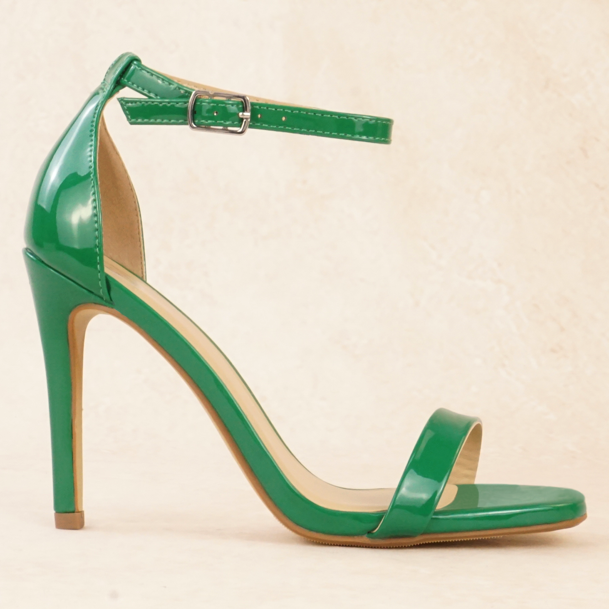 A green patent material stiletto heel with adjustable ankle strap
