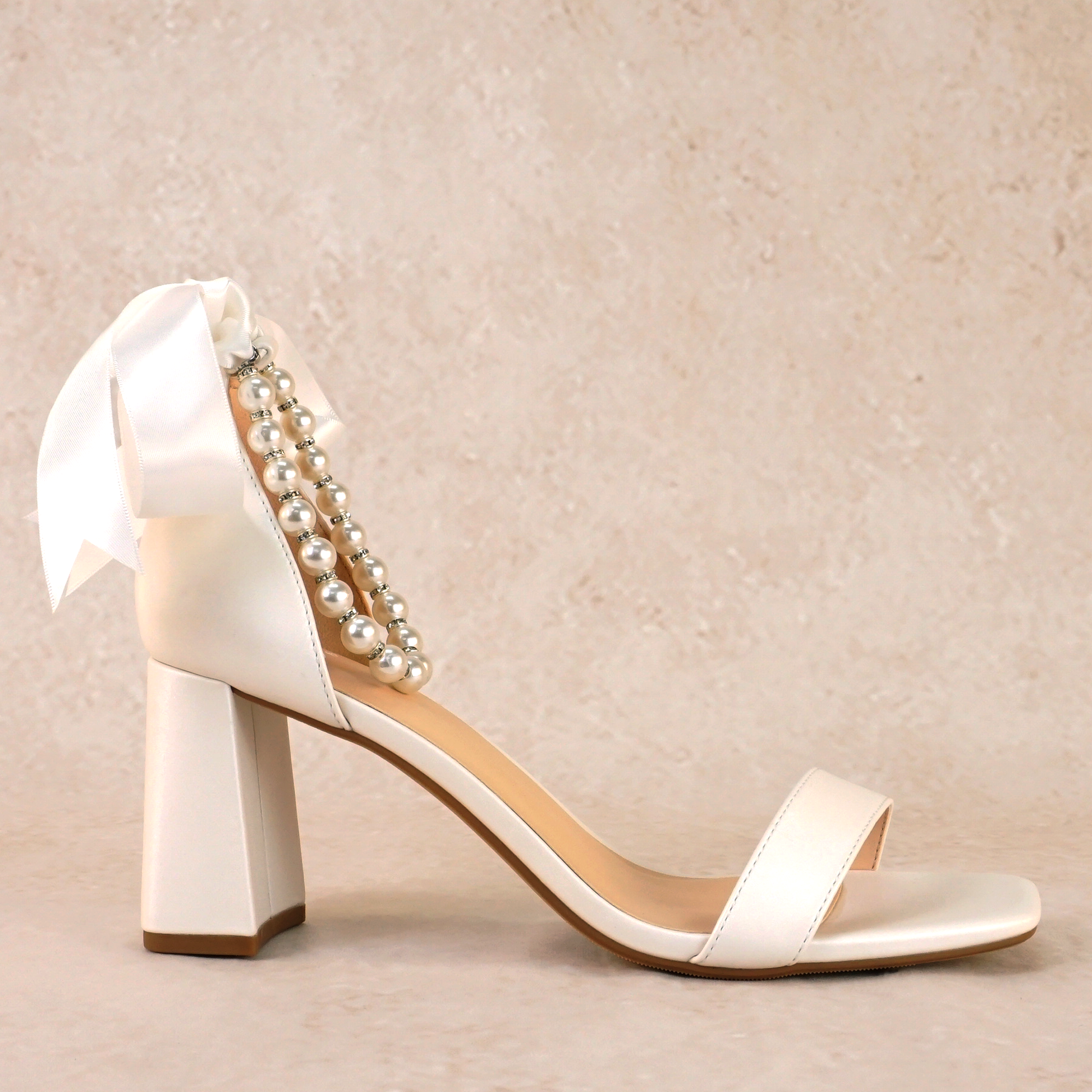 3" flared block heel in white with adjustable pearl ankle strap and satin ribbon tie