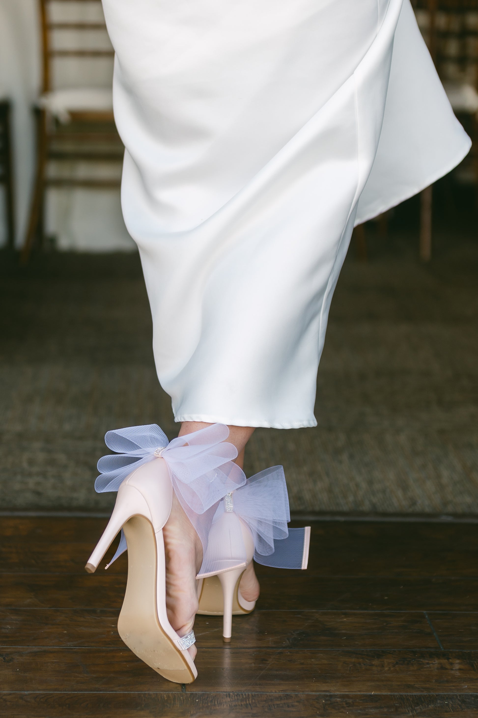 4" stiletto heel in pink with rhinestone band and wire mesh statement bow worn by a woman in a white dress