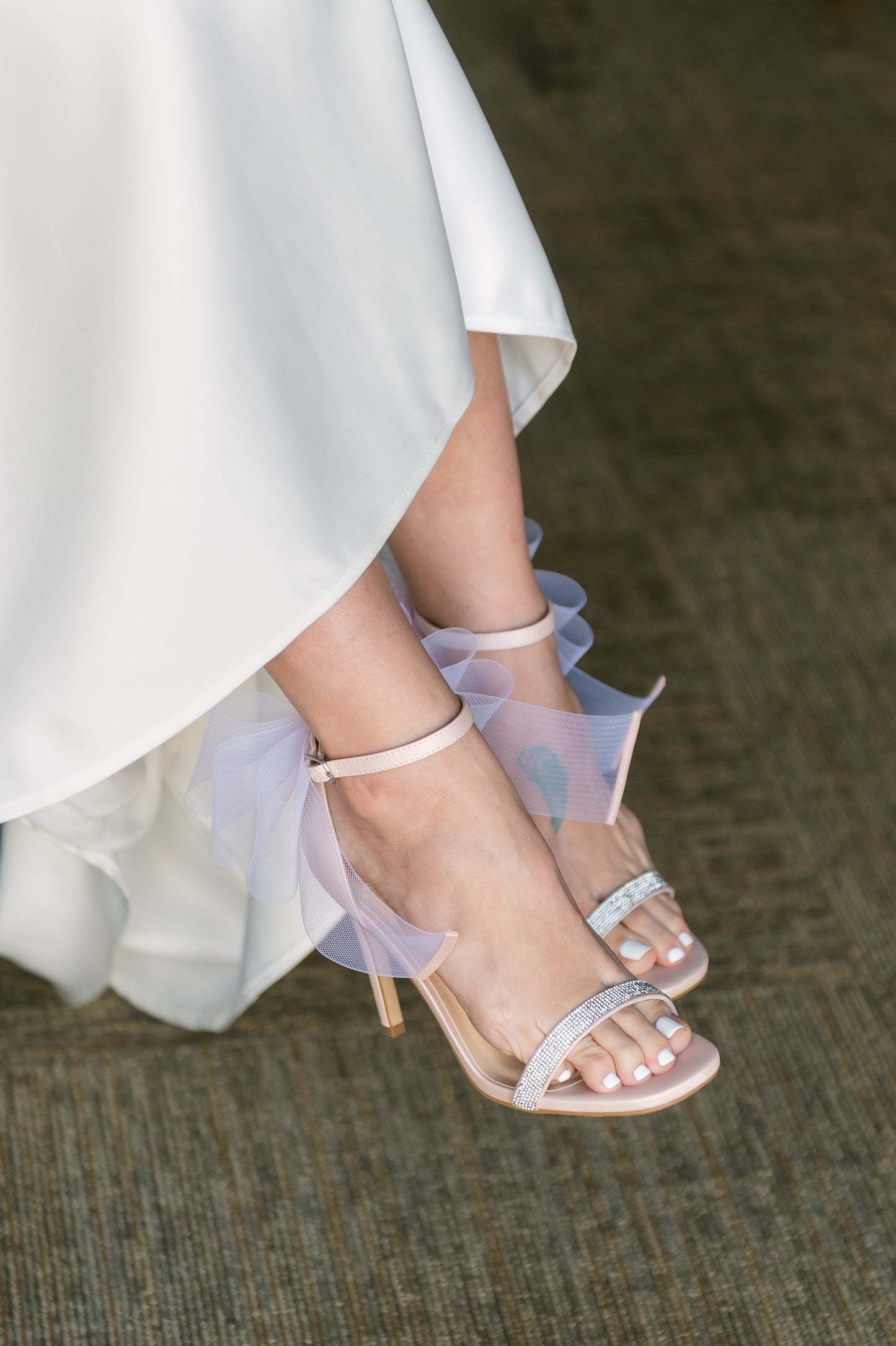 4" stiletto heel in pink with rhinestone band and wire mesh statement bow worn by a woman in a white dress