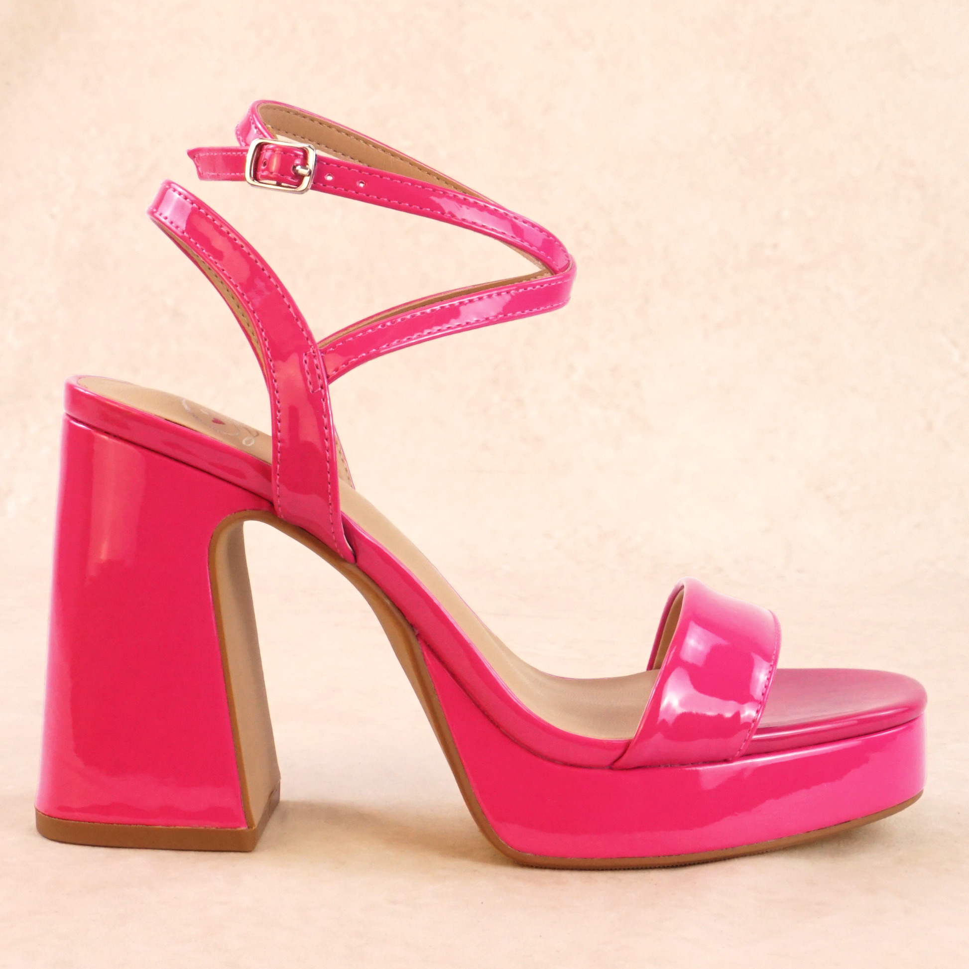 A pink patent material platform high heel with adjustable ankle strap