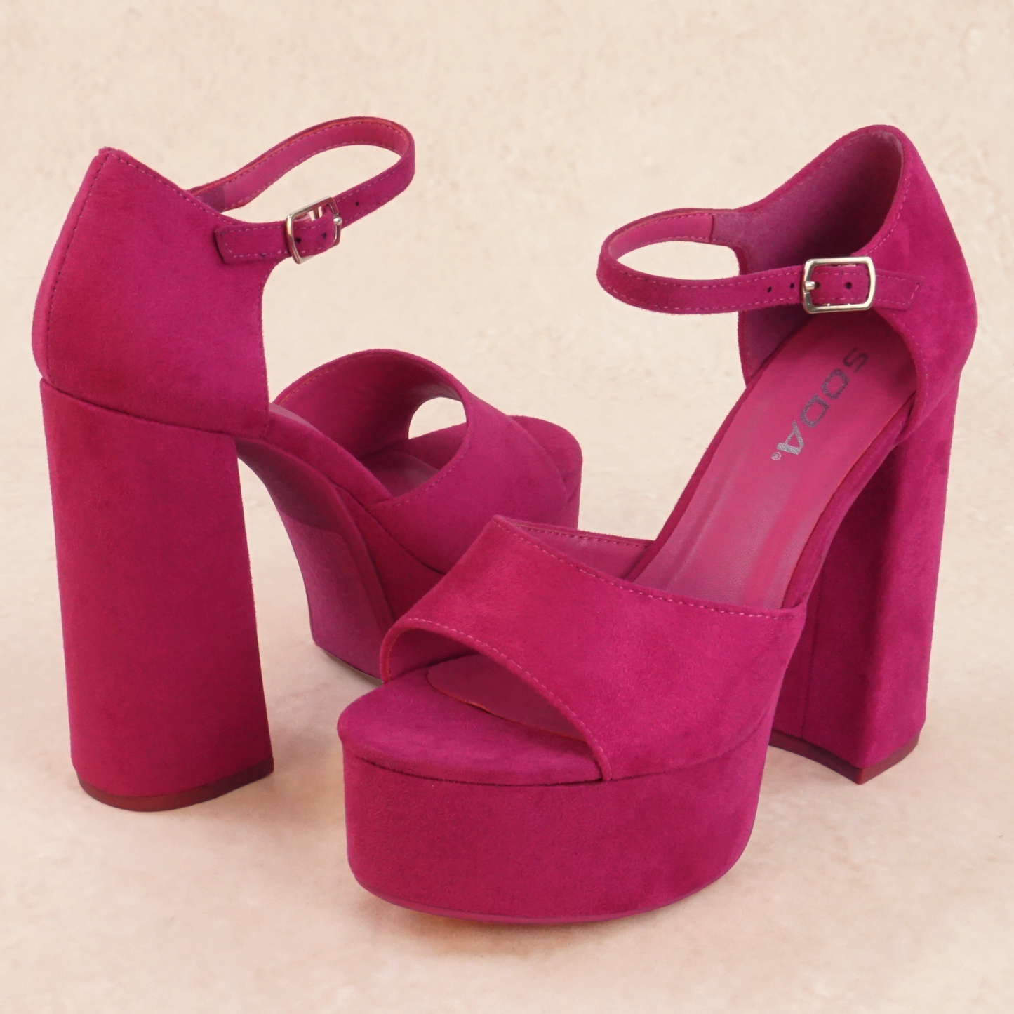 A pair of pink platform high heels with adjustable buckle ankle strap