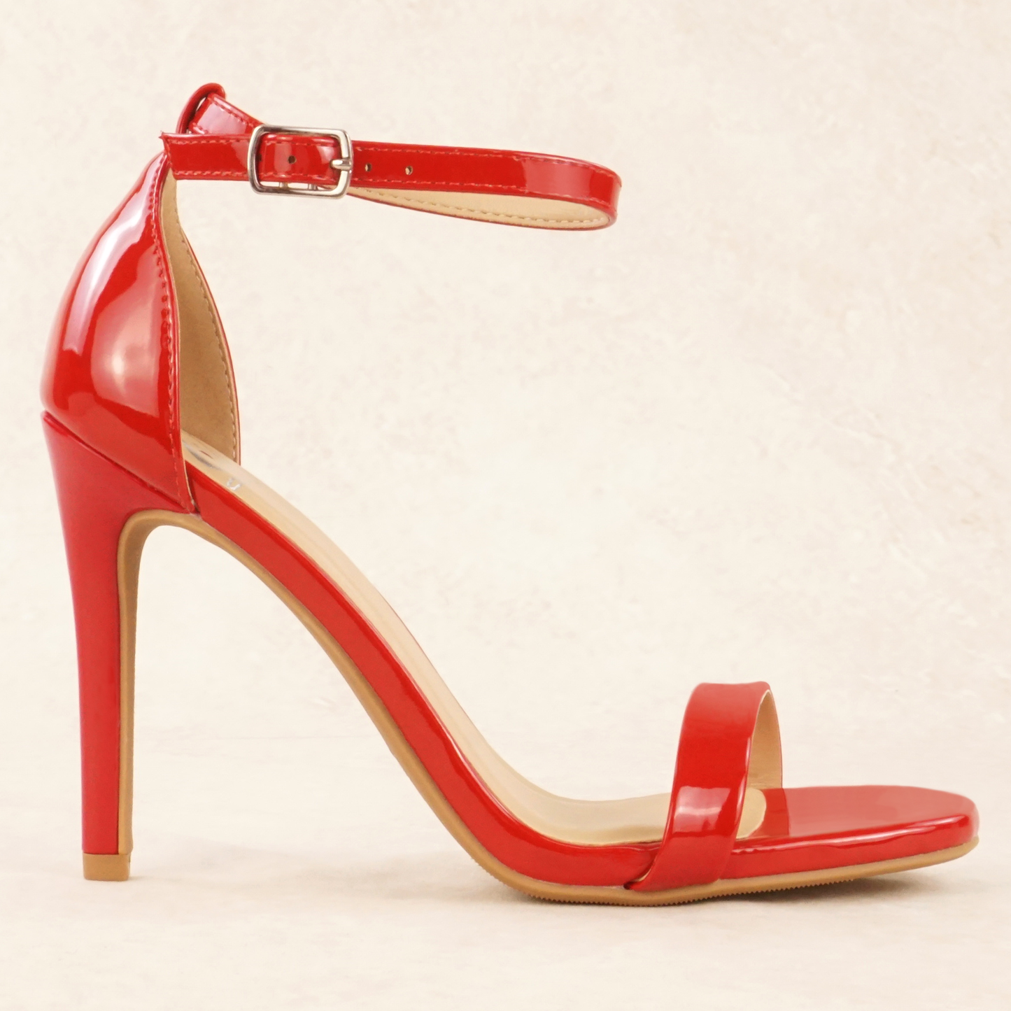 A red patent material stiletto heel with adjustable ankle strap