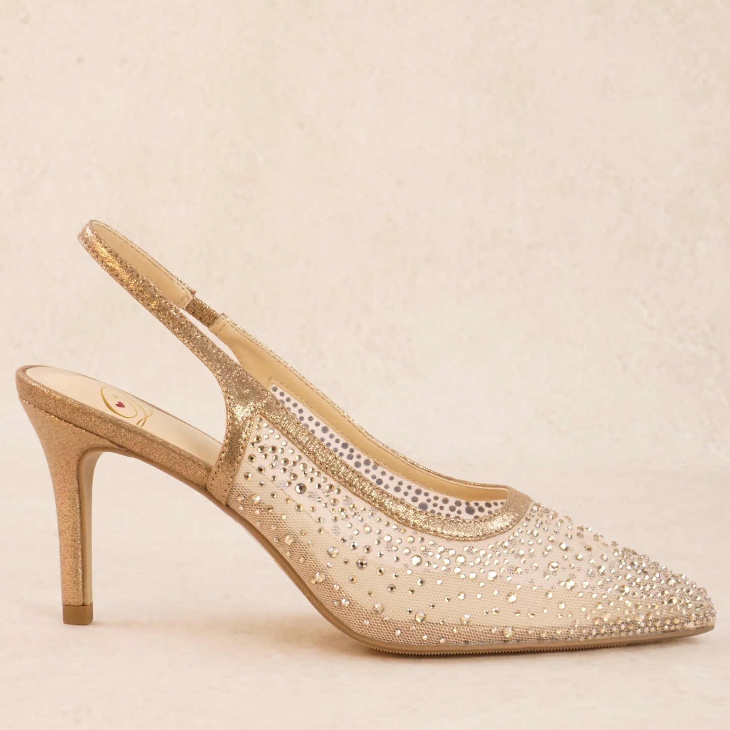A rose gold mesh rhinestone studded pump heel with elastic slingback strap