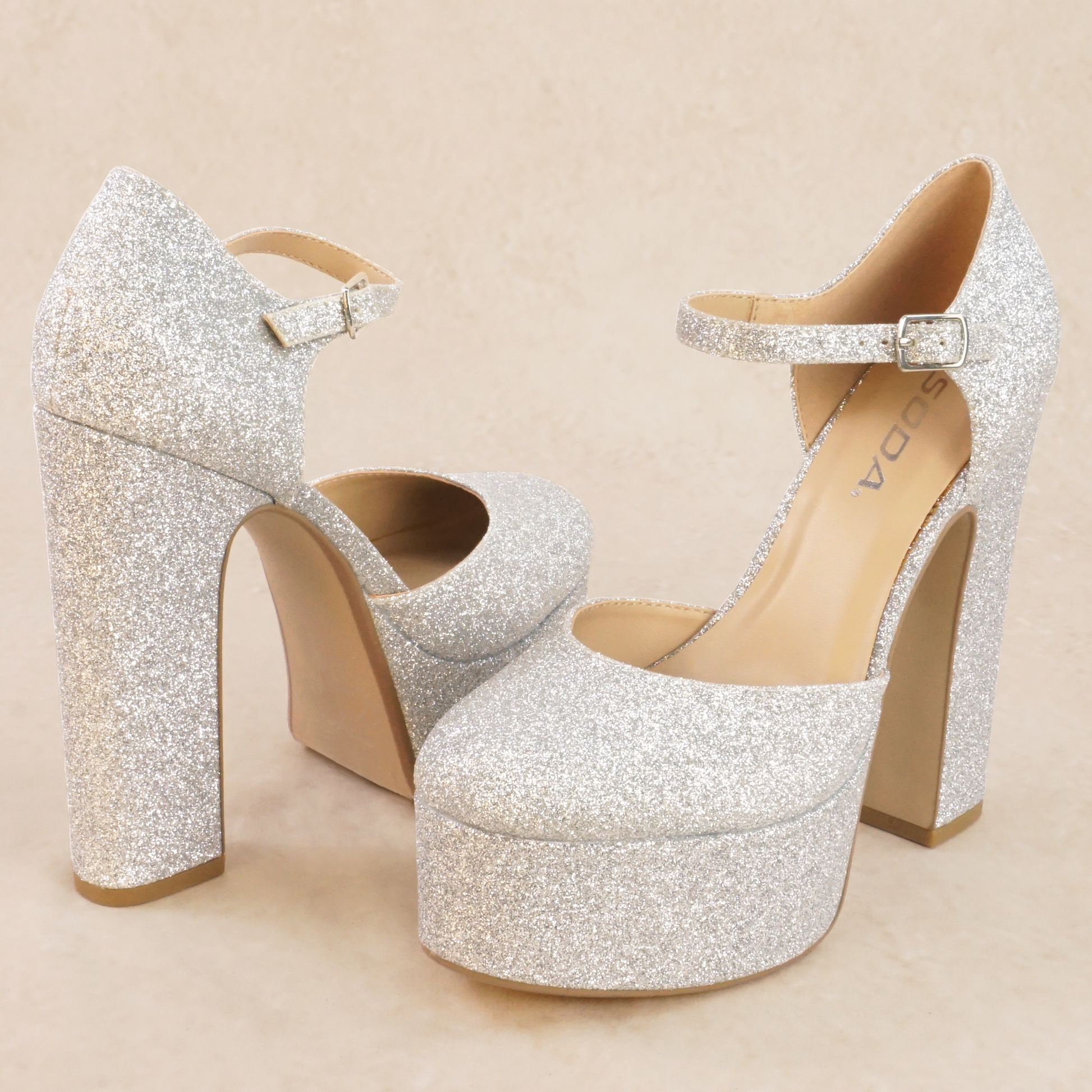 A pair of silver glitter platform high heels with adjustable ankle strap