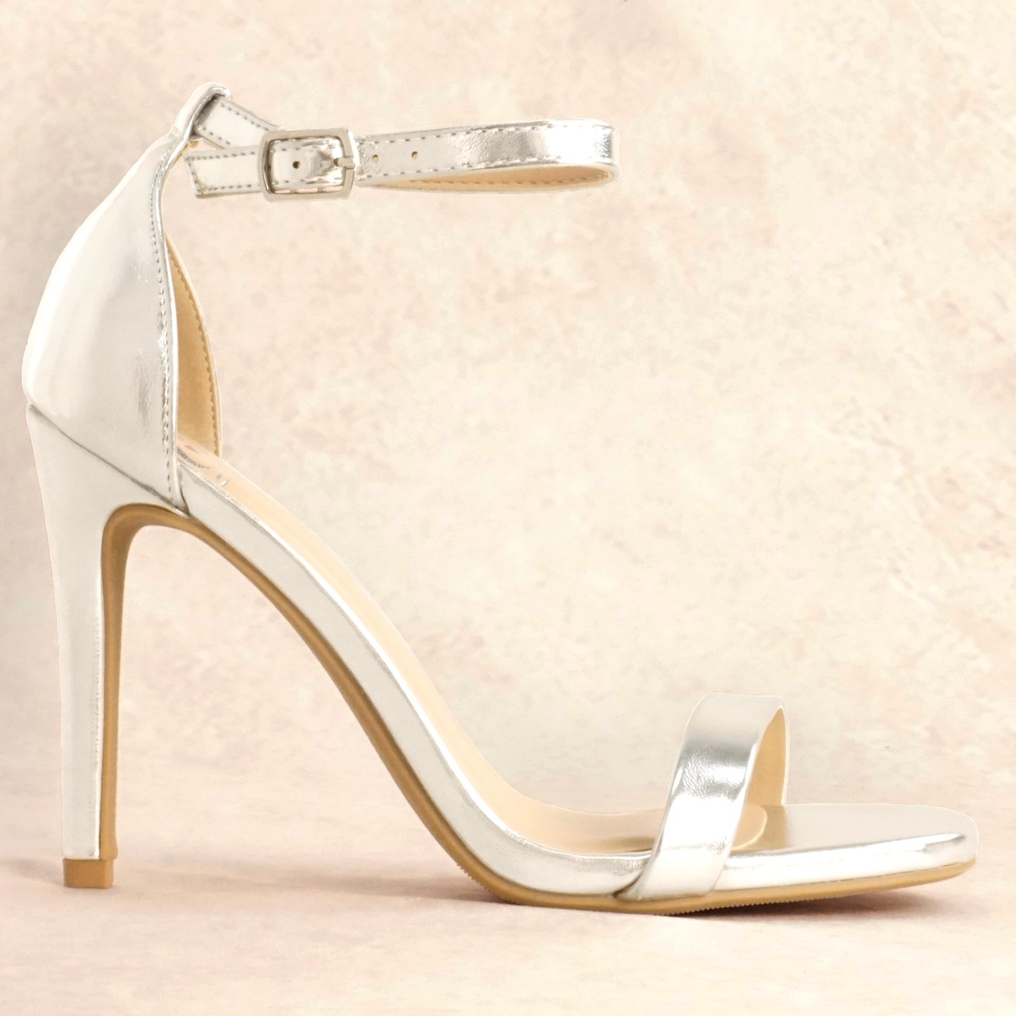 A silver metallic stiletto heel with adjustable ankle strap