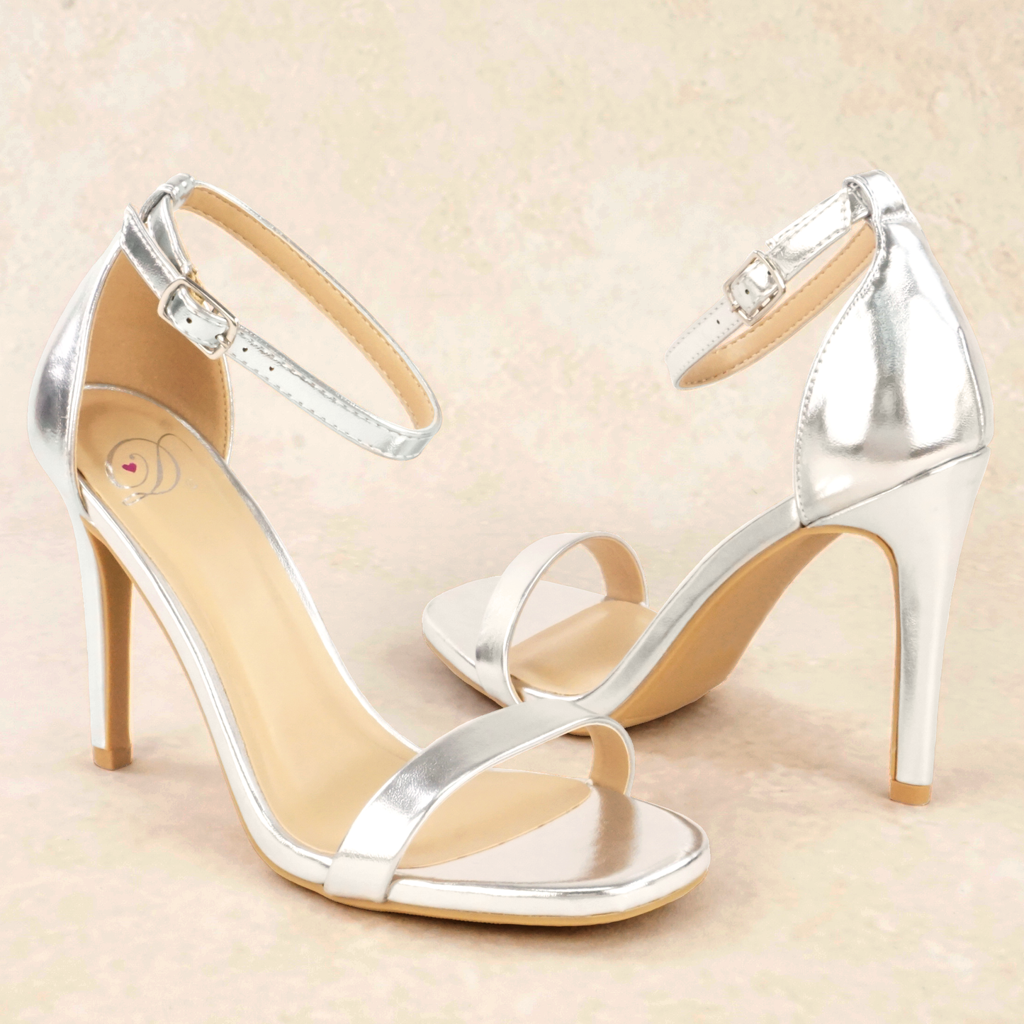 A pair of silver metallic stiletto heels with adjustable ankle straps