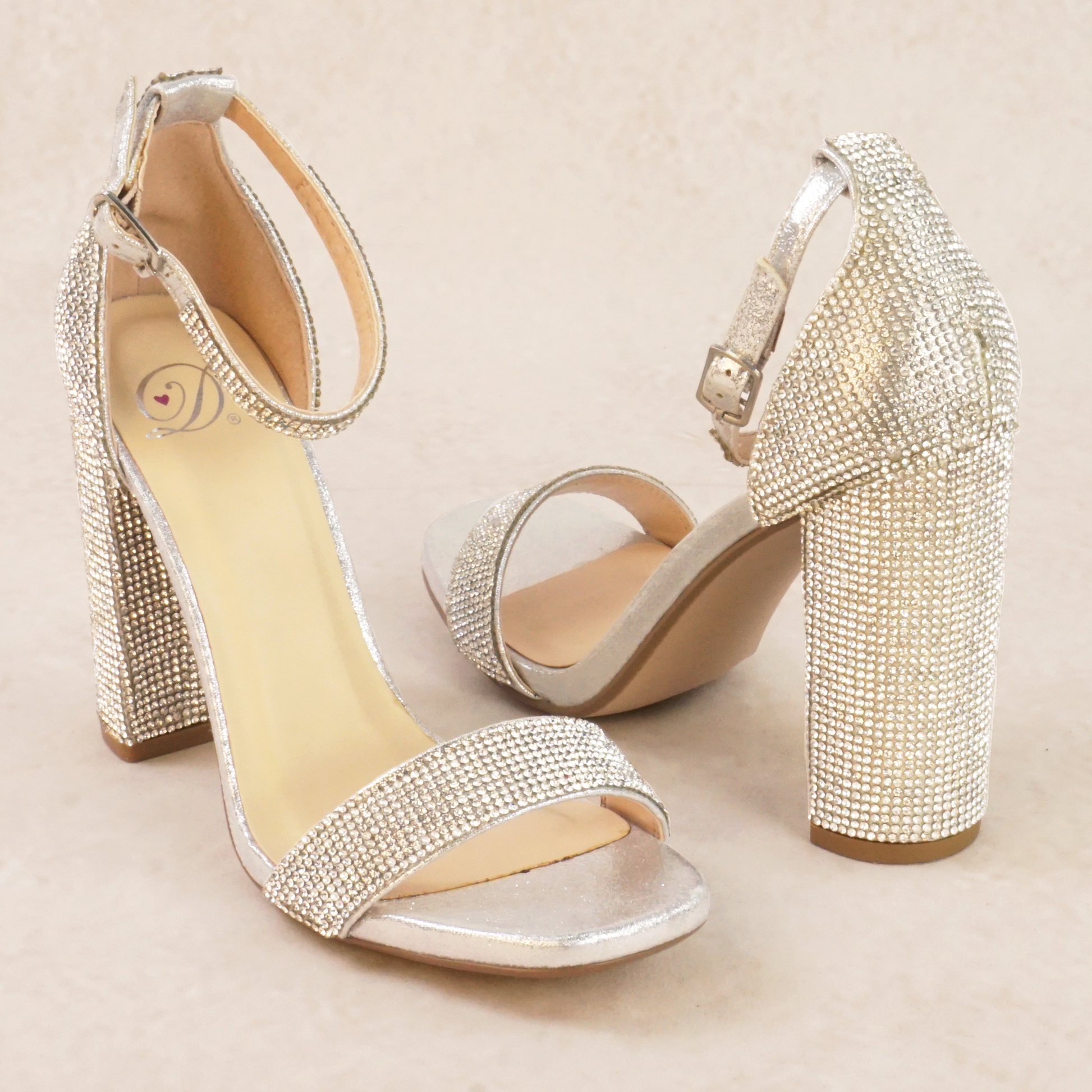 A pair of silver rhinestone high heels with adjustable ankle strap