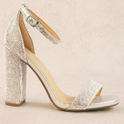 A silver rhinestone studded high heel with adjustable ankle strap