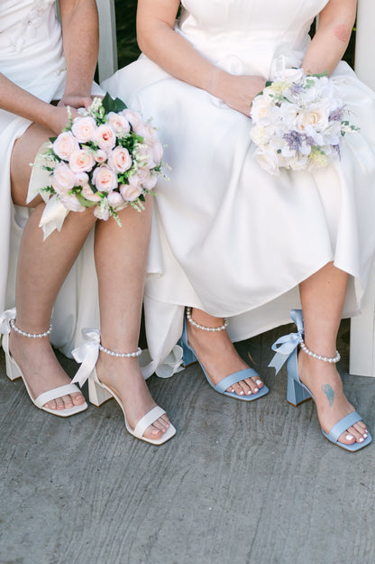3" flared block heels in blue and white with adjustable pearl ankle strap and satin ribbon tie worn by two women in white dresses