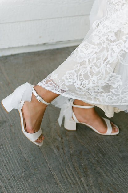 Simple low 2.5" block heel in white with a bow at the back