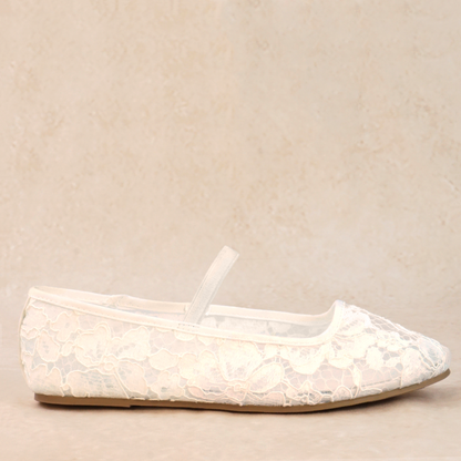 A white flat shoe with floral lace pattern allover and Mary Jane style elastic strap