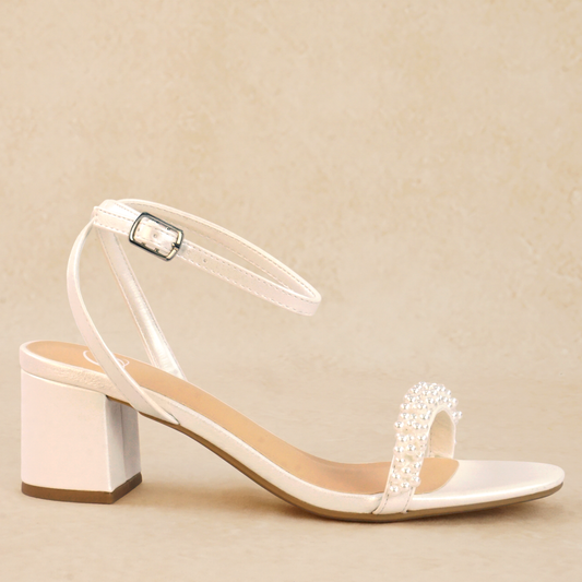 A white pearlescent block heel with pearls and adjustable ankle strap