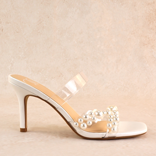 White stiletto slide with pearls on a lucite cross-strap with a 3.5" stiletto heel
